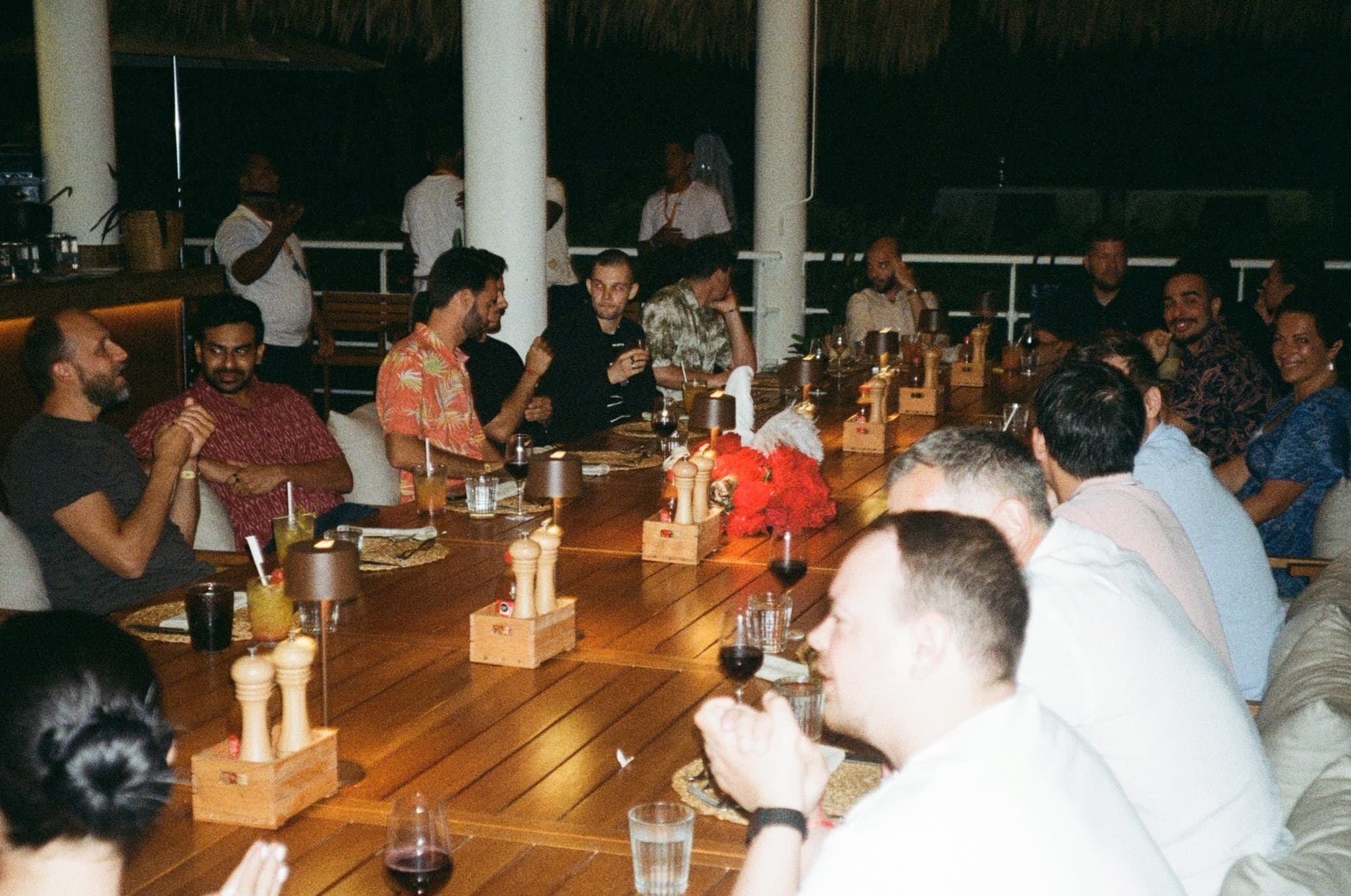 The MUI team sits around a large rectangular table for dinner.